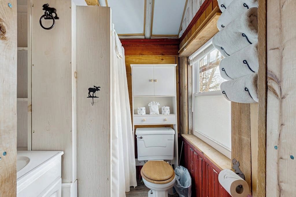 Une petite salle de bain comprenant des toilettes, un lavabo et une fenêtre.