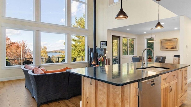 Una cocina amplia con una isla grande, armarios de madera y vistas al exterior.