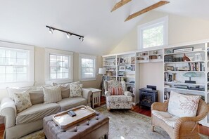 A cozy living room with a sofa, armchair, ottoman, and bookshelf. - Historical New England Home, Outdoor Shower , Dog-friendly (Boothbay Harbor)