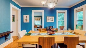 Een eetkamer met een houten tafel, stoelen en een kroonluchter.