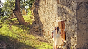 A stone building with a doorway, a tree, and a pathway. - Maison Cøva: The Essentials in Their Raw Form (Castelnau-sur-l'Auvignon)