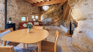 A stone-walled interior with a dining area, wooden furniture, and a fireplace. - Maison Cøva: The Essentials in Their Raw Form (Castelnau-sur-l'Auvignon)