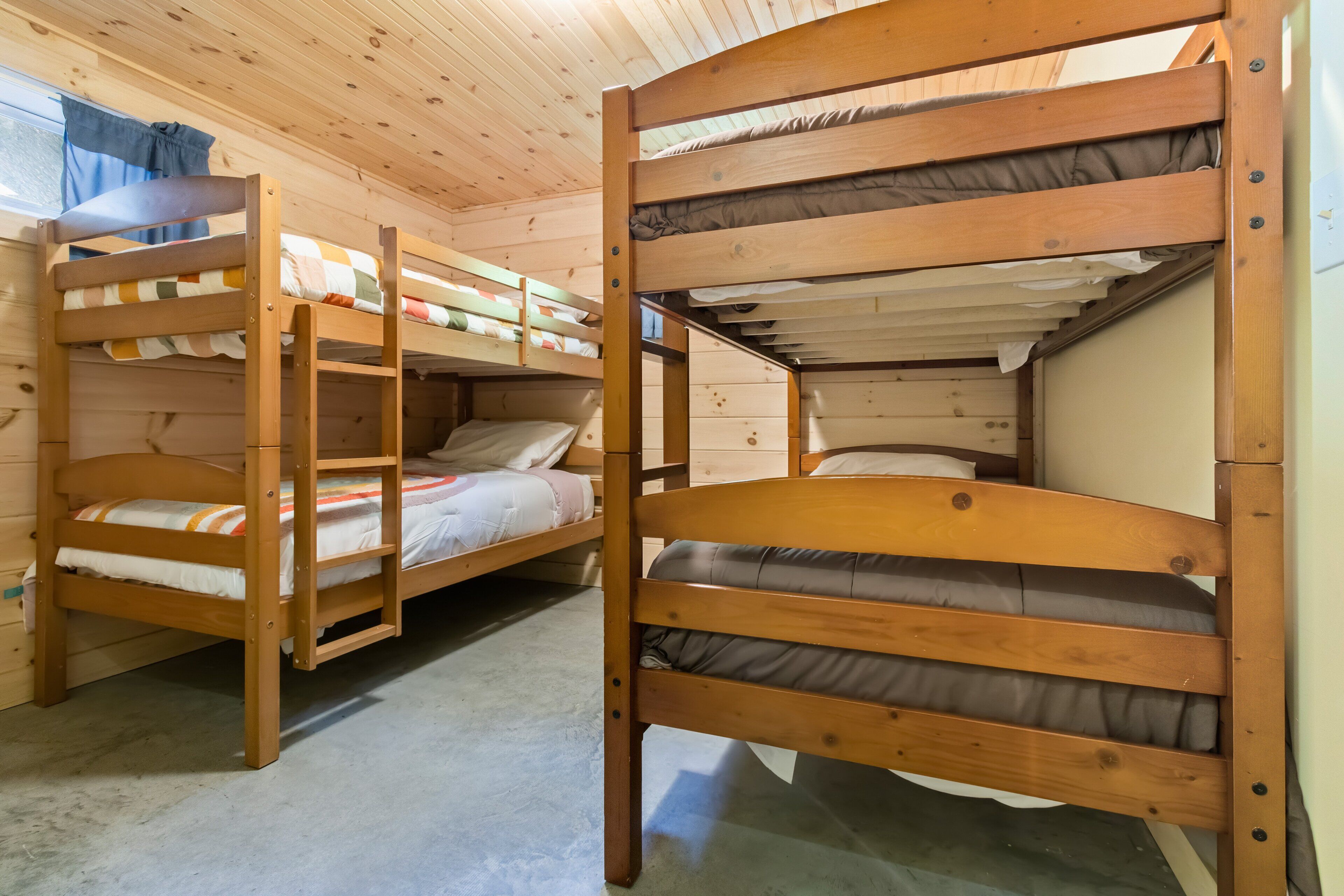 A bunk bed room with wooden frames and mattresses.