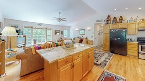 A spacious kitchen with wooden cabinets, a central island, and a large refrigerator. - Inviting Dog-friendly Home With Firepit & Ping-pong - Near Acadia National Park (Ellsworth)
