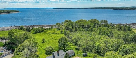 A house with a large deck and a view of a lake.