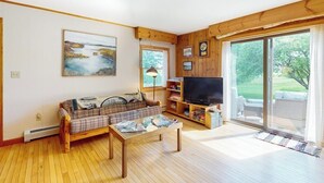 En stue med sofa, sofabord, fjernsyn og reol.