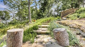 A stone pathway leading through a forested area with a stone staircase and tree stumps. - Dog-friendly Home With High-speed Wifi, Washer/dryer, & Private Dock (Harpswell)