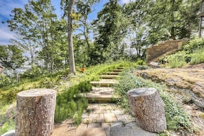 A stone pathway leading through a forested area with a stone staircase and tree stumps. - Dog-friendly Home With High-speed Wifi, Washer/dryer, & Private Dock (Harpswell)