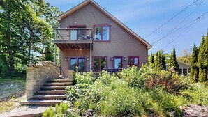 A two-story house with a balcony, a stone staircase, and a garden. - Dog-friendly Home With High-speed Wifi, Washer/dryer, & Private Dock (Harpswell)