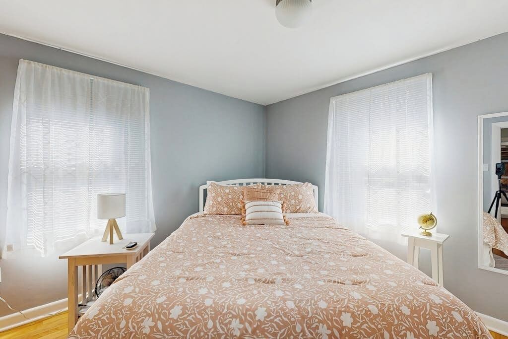 Een slaapkamer met een bed, nachtkastjes en een spiegel.