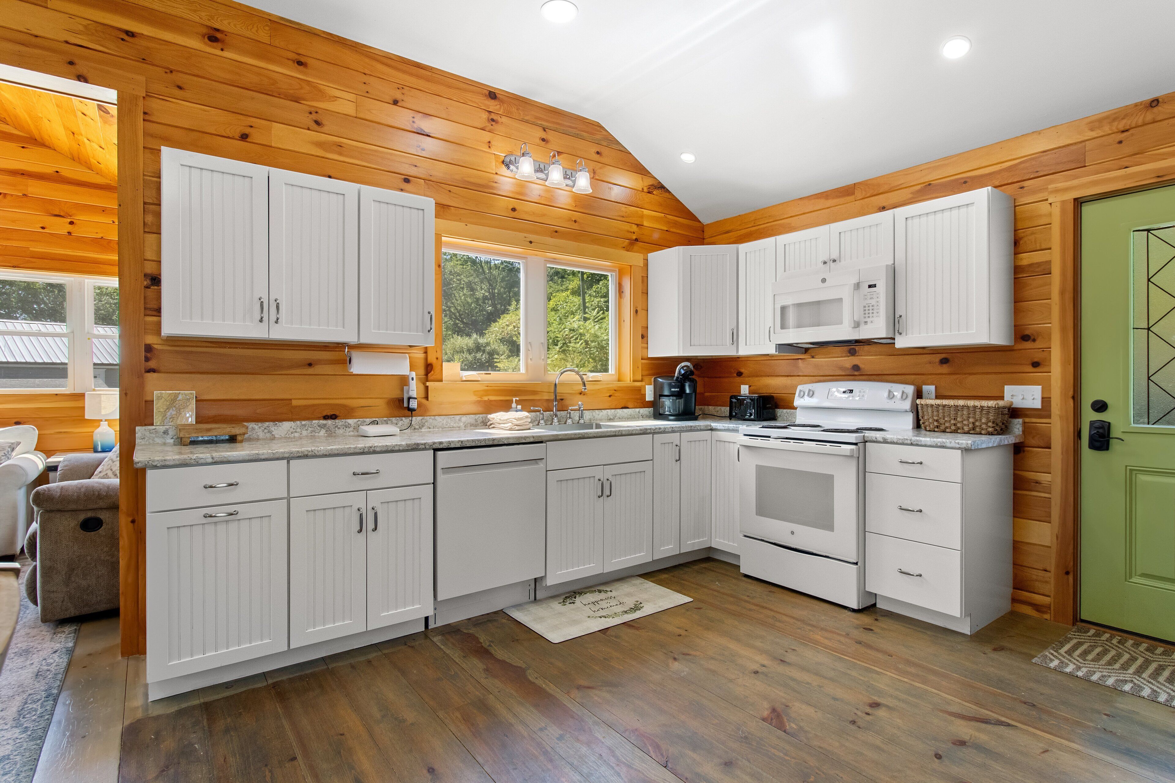 A modern kitchen with white cabinetry, a built-in microwave, and a stove.