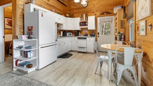 A wooden interior with a kitchen, dining area, and a staircase. - Waterfront Home on Graham Lake With Kayaks, Bikes, Firepit & Fireplace (Ellsworth)