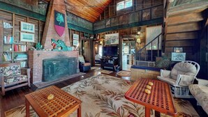 Un interior rústico con chimenea, paredes de madera y un techo alto.