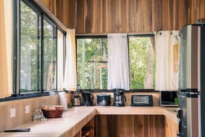Une cuisine équipée d’un plan de travail en bois, d’une machine à café, d’un grille-pain et d’un réfrigérateur.