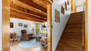 Una escala de fusta que porta a una habitació amb escriptori, cadira i vistes a l'exterior.