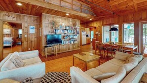 Ambiente in legno con soggiorno, zona pranzo e cucina.