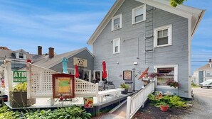 A two-story building with a porch, a sign for 'Mama's Cafe,' and an ATM. - Charming, Historic Cottage With Modern Upgrades - Stroll to Dining & Attractions (Boothbay Harbor)