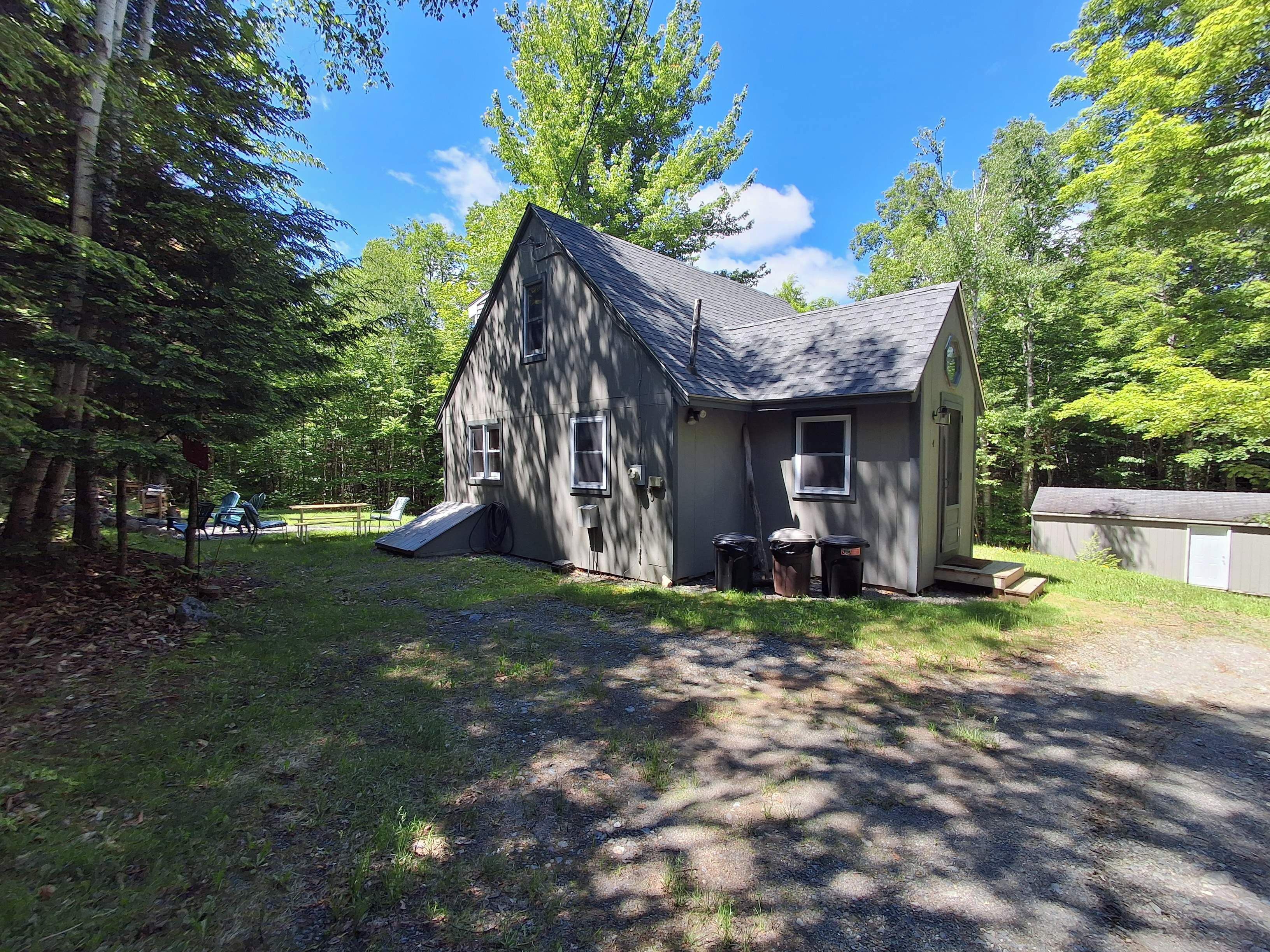 Une maison à deux étages, dotée d’un toit en pente, d’un petit porche et d’une rampe menant à la porte d’entrée.