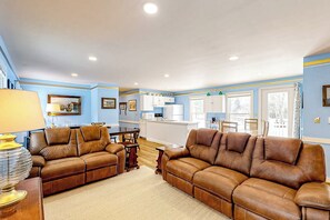 A living room with two brown leather sofas, a wooden coffee table, and a lamp.