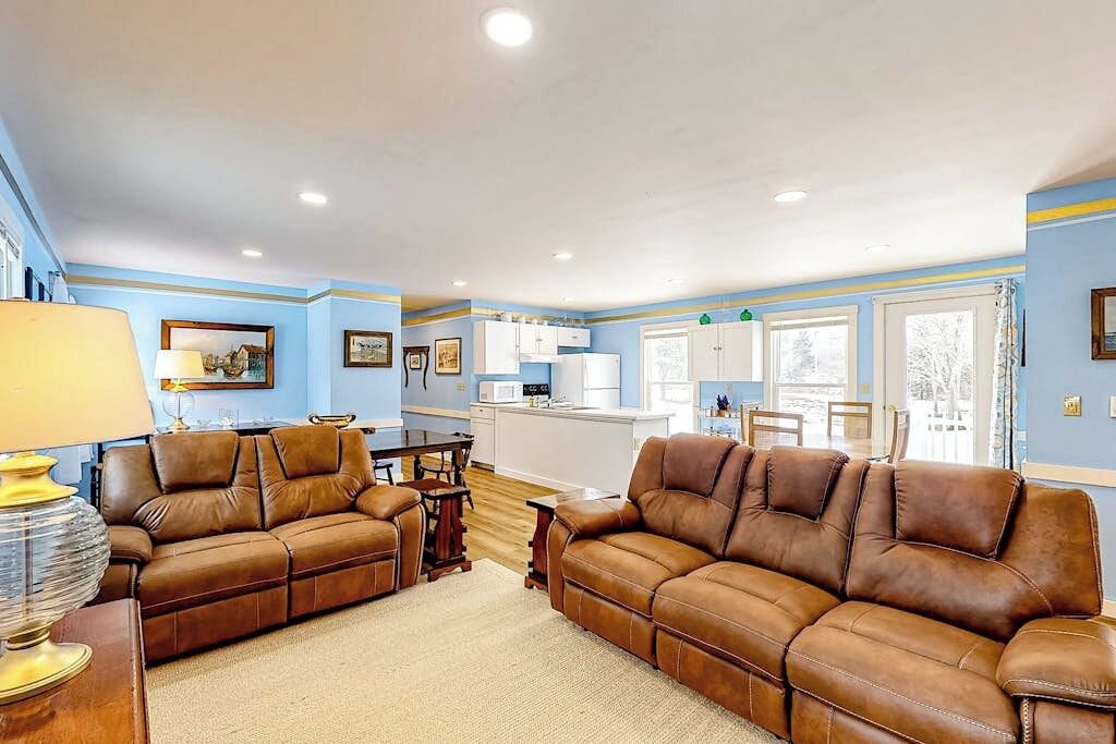 A living room with two brown leather sofas, a wooden coffee table, and a lamp.