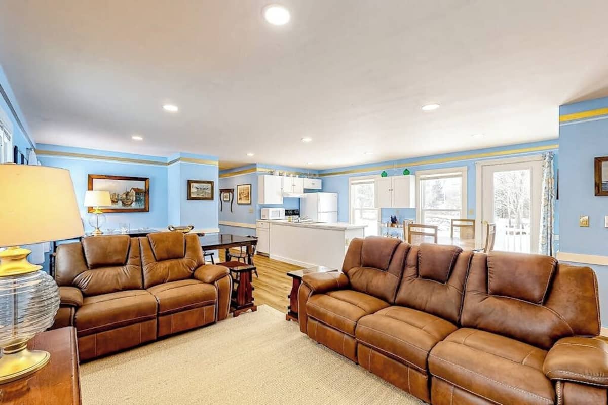 A living room with two brown leather sofas, a wooden coffee table, and a lamp.