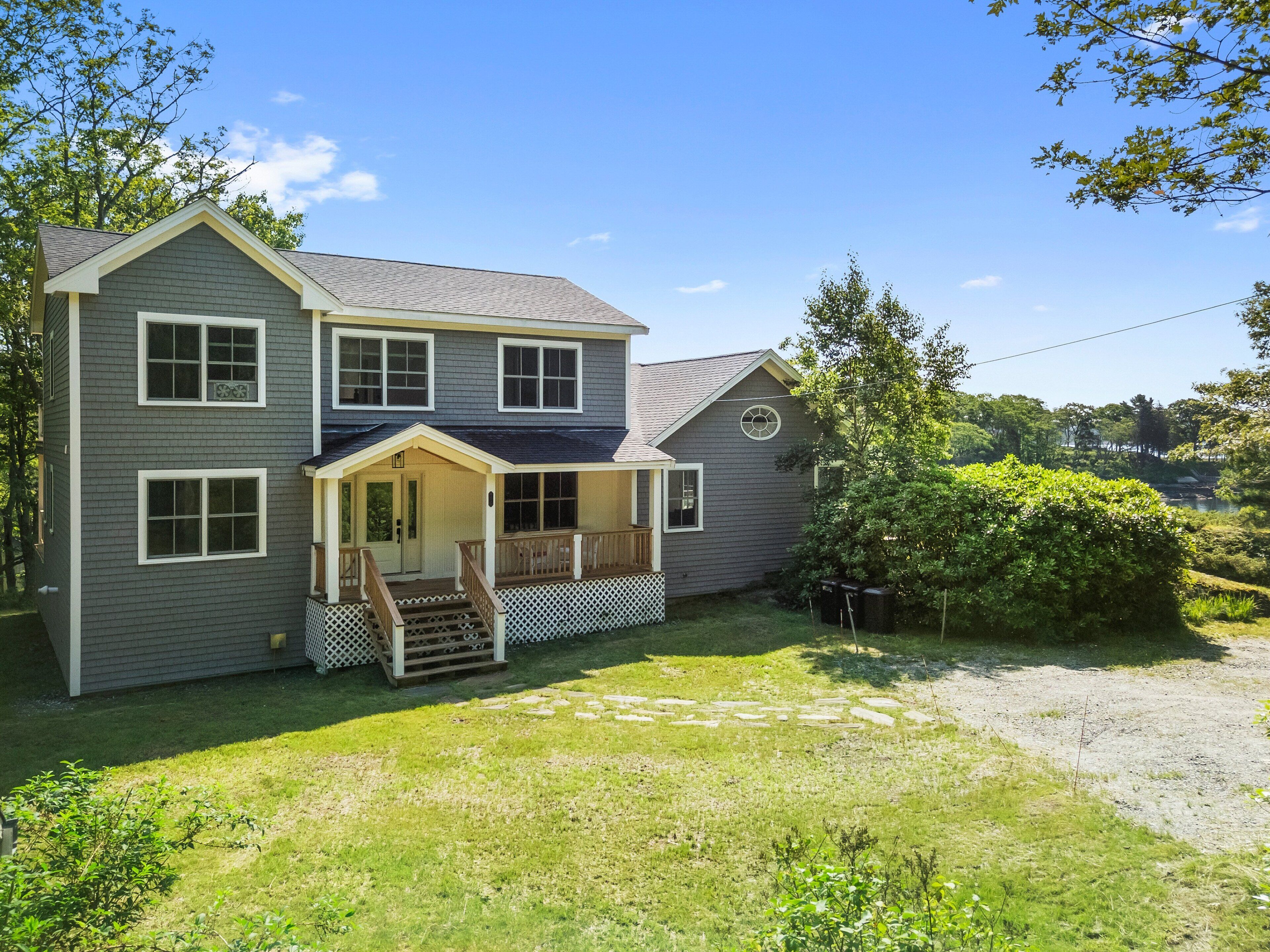 A two-story house with a front porch, a covered entryway, and a small front yard.
