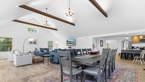 A spacious living area with a dining table, sofas, and a kitchen in the background. - Gorgeous Oceanfront Home With Hot Tub, Modern Remodel, and Stunning Views (Wiscasset)