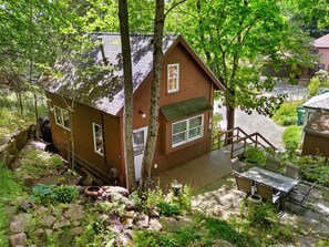 A small brick house with a wooden deck and a staircase leading to a porch. - Two-level Unit w/ Patio, Deck, Firepit, Private Washer/ Dryer, and Free Wifi (Seal Harbor)