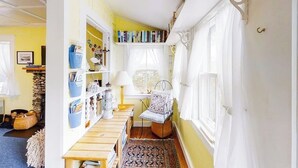 A narrow hallway with a wooden bench, a patterned rug, and a window with white curtains. - Dog-friendly Fisher Hill Home With Patio and Wood Stove - Walk to the Harbor (Boothbay Harbor)