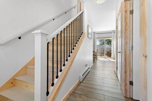 A staircase with wooden steps and black balusters leading to an upper floor. - Ocean Breeze (Owls Head)