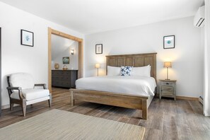 Un dormitorio con una cama de madera, una silla, un tocador y un espejo.