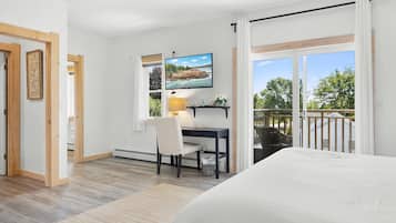 Une chambre à coucher comprenant un lit, un bureau avec une chaise, un téléviseur et une fenêtre donnant sur l’extérieur.