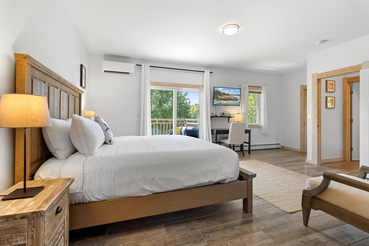 A bedroom with a large bed, a desk, and a chair.