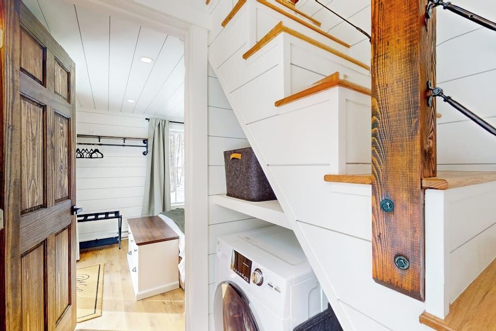 A staircase with wooden handrails and a white wall with built-in shelves.