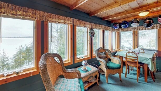 Ein gemütliches Zimmer mit großen Fenstern, Korbmöbeln und einem für das Essen gedeckten Tisch.