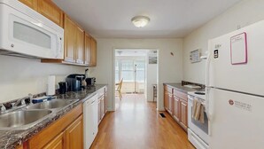 Una cocina con armarios de madera, un microondas, un refrigerador y un lavaplatos.