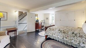 Un dormitorio con cama, cómoda y escalera.