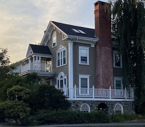 A two-story house with a stone foundation, a brick chimney, and a white picket fence. - Historic Condo in Downtown Camden, Steps to Harbor (Camden)