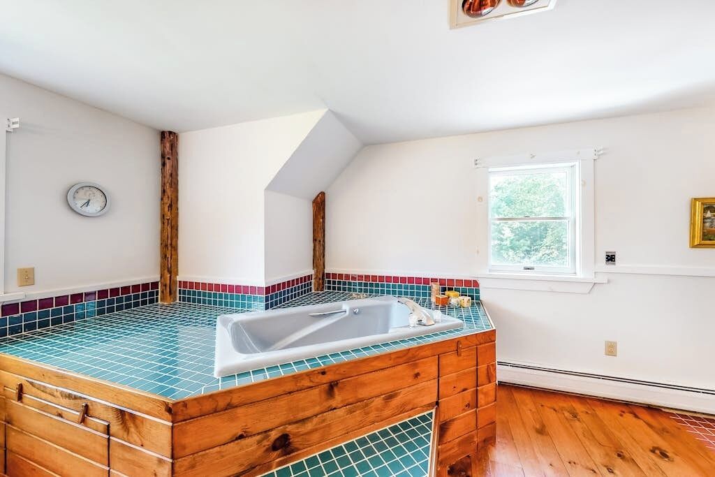 Un bagno con un mobile lavabo in legno, un lavandino e una finestra.