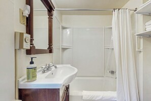A bathroom with a white sink, a mirror, a shower curtain, and a towel rack. - Quaint Family-friendly Cottage Near Main Street W/free Wifi and Partial A/C (Bar Harbor)