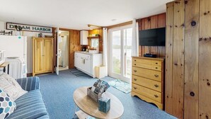 Ein kompakter Wohnraum mit Küchenzeile, Fernseher und einem Schild mit der Aufschrift 'Dream Harbor'.