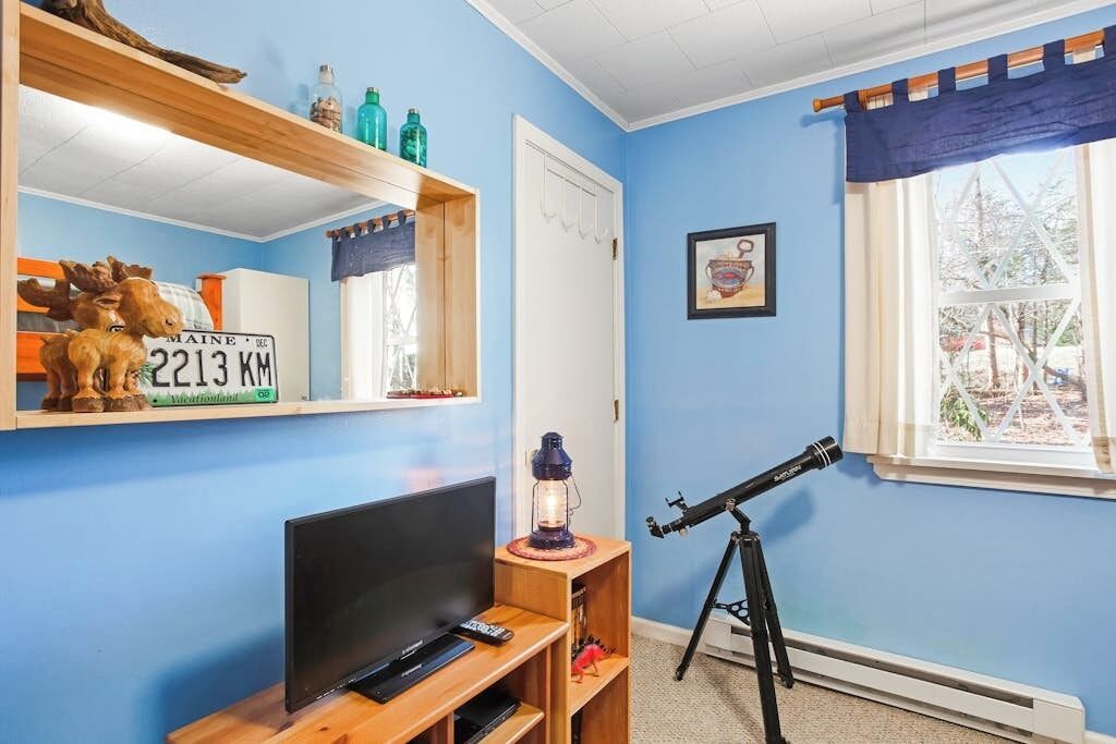 Ein Zimmer mit Fernseher, Teleskop, Tür und Fenster mit Blick.