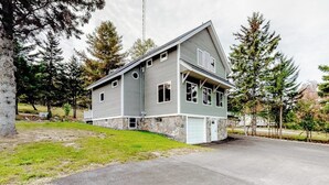 A two-story house with a stone foundation, a garage, and a driveway. - Charming Riverfront Home With Mountain Views & Private Dock (Rockwood)