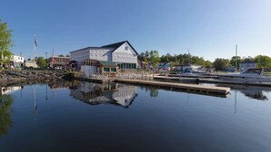 En fastighet vid vattnet med en brygga, en byggnad med ett sadeltak och en klar himmel.