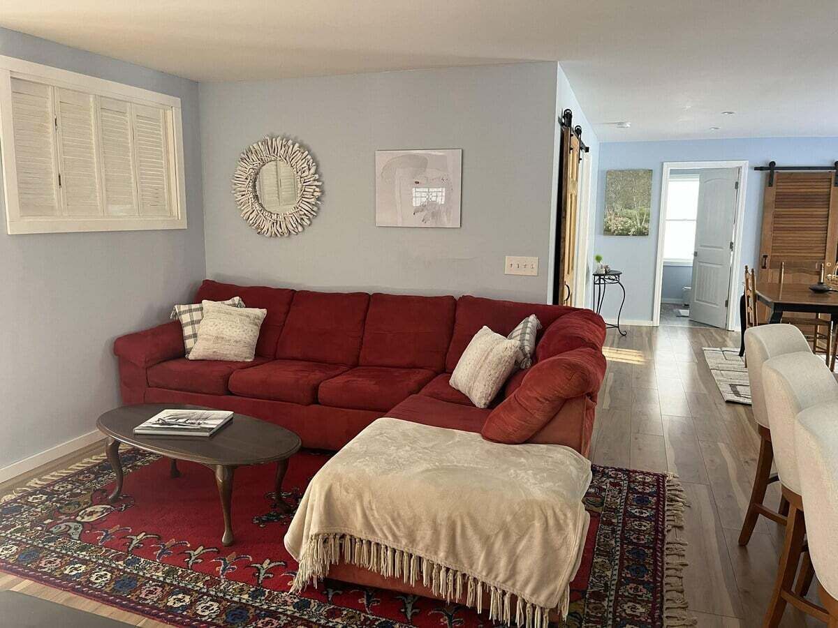 Un salon avec un canapé rouge, une table basse et un tapis à motifs.