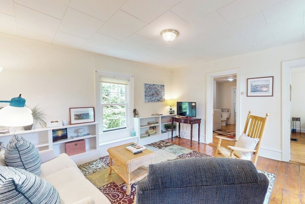 A living room with a sofa, a coffee table, a TV, and a bookshelf.