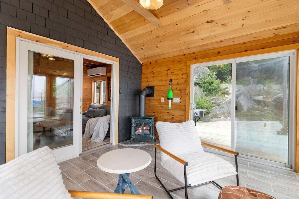 A cozy cabin interior with a fireplace, a dining table, and a comfortable seating area.