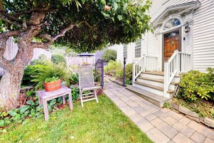 A house with a front porch, steps, and a wooden fence.