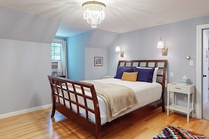 A bedroom with a wooden bed, a chandelier, a bedside table, and a window. - Woodland Home With Screened Porch, 2 Living Rooms - Near Historic Waterfront (Bath)