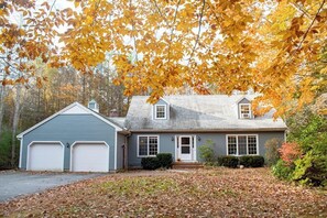 A two-story house with a garage, a front porch, and a driveway. - Woodland Home With Screened Porch, 2 Living Rooms - Near Historic Waterfront (Bath)
